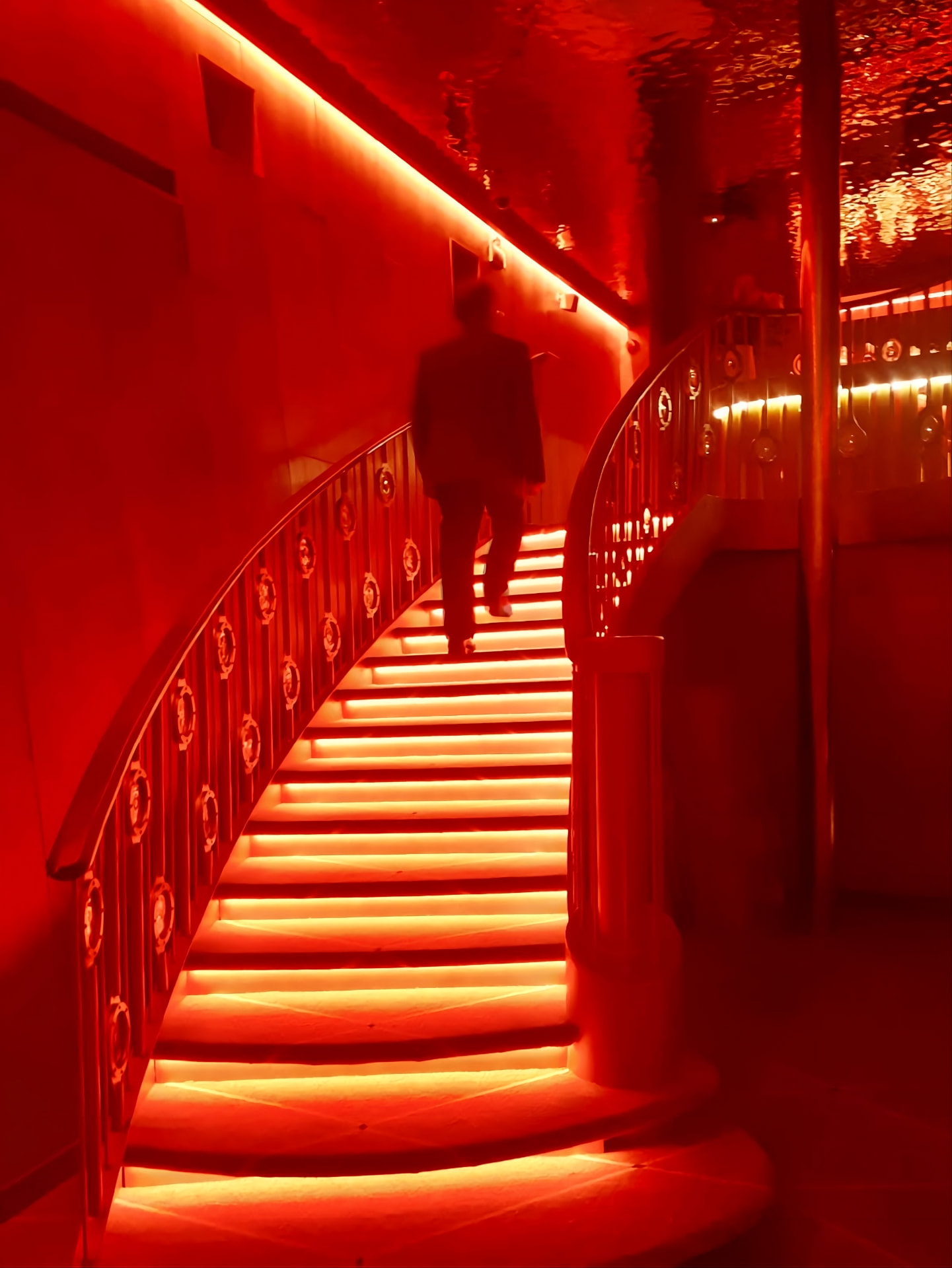 A figure ascending a glowing red staircase