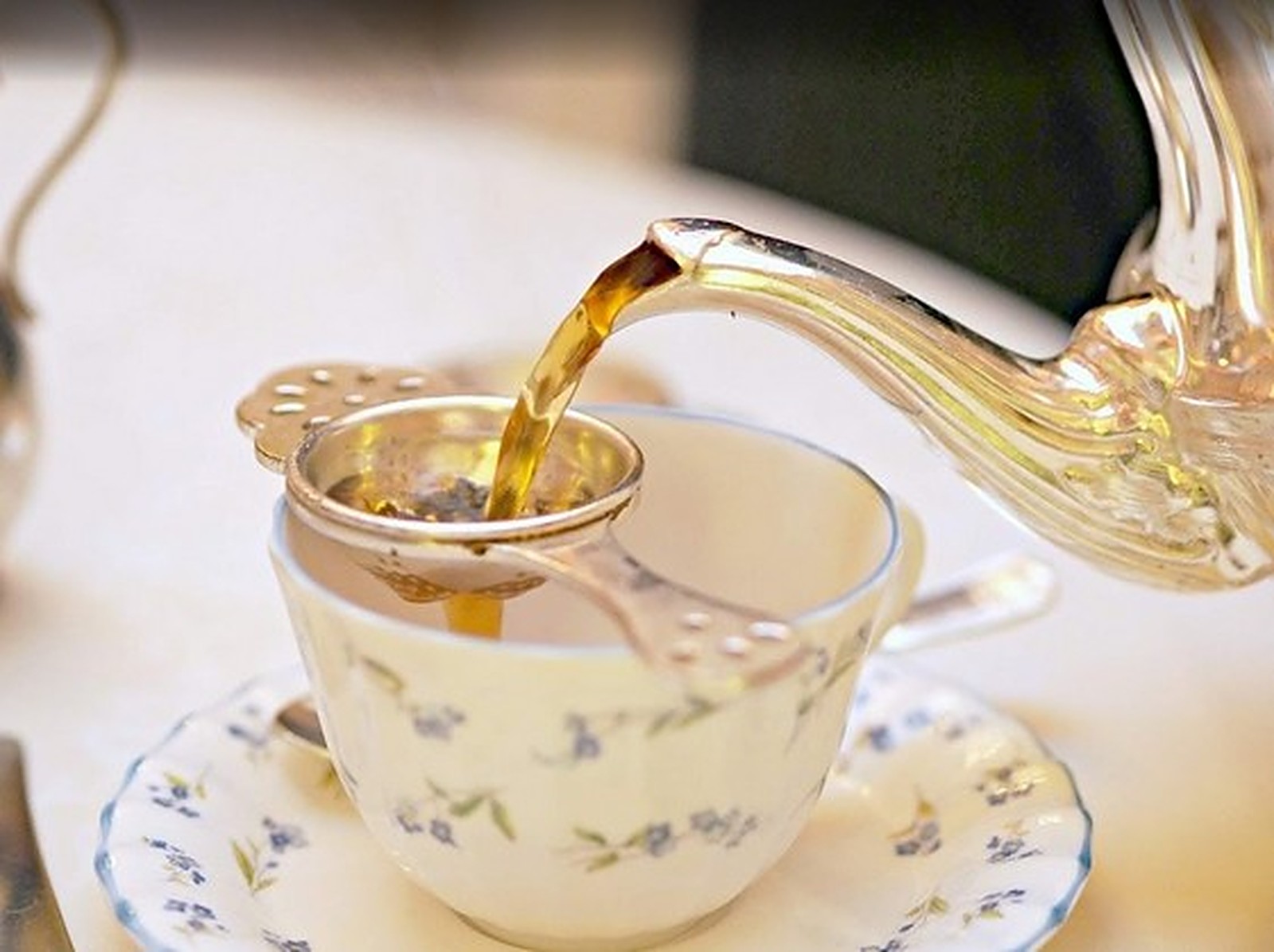 Tea being poured into a porcelain cup